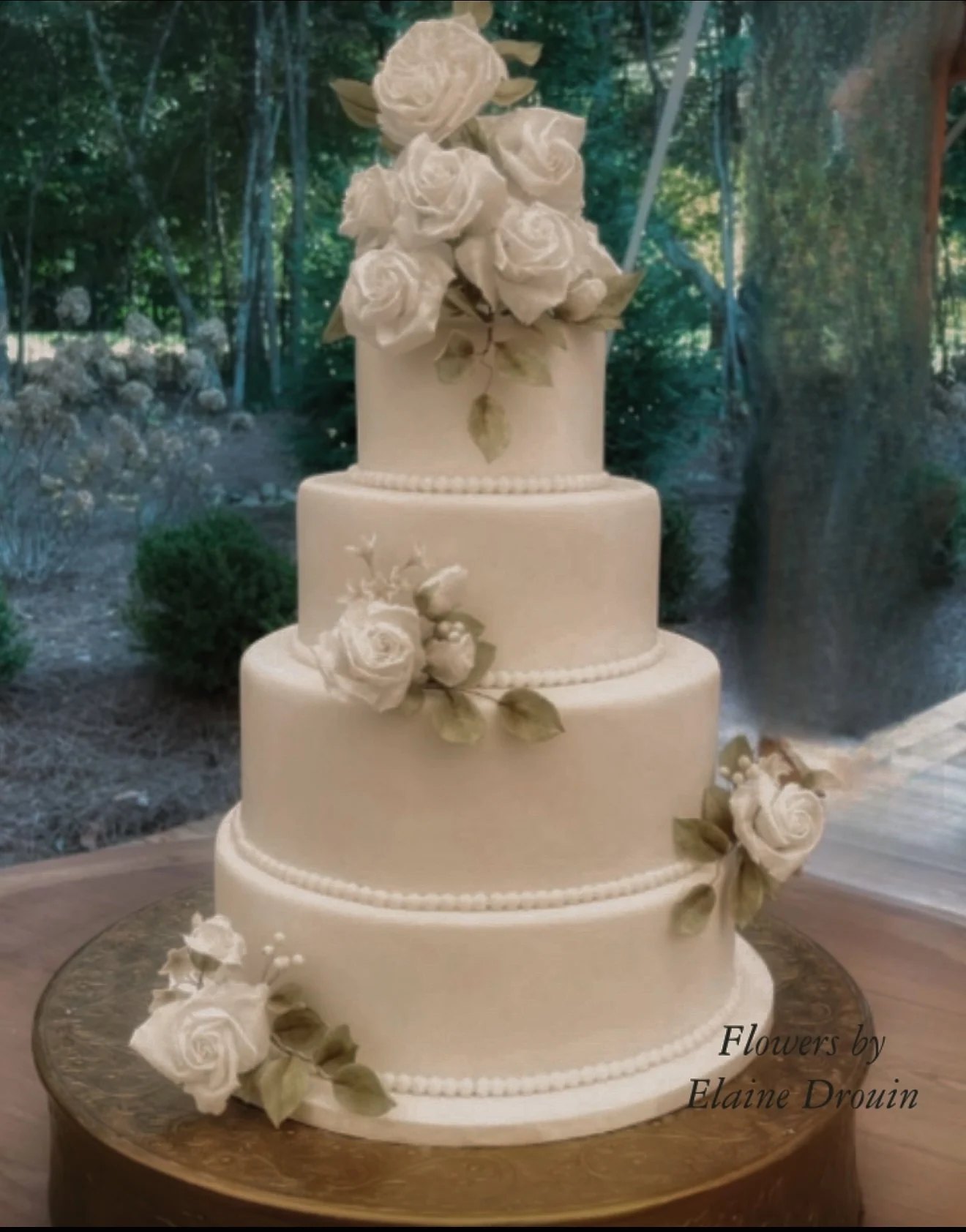 A white wedding cake finished with handmade sugar flowers