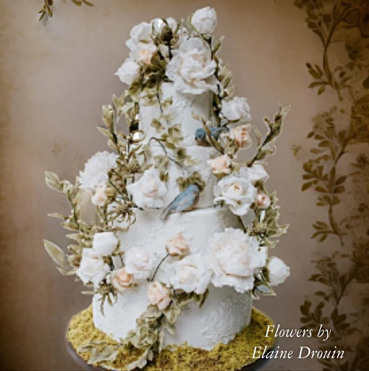 A tiered cake with intricate white sugar flowers