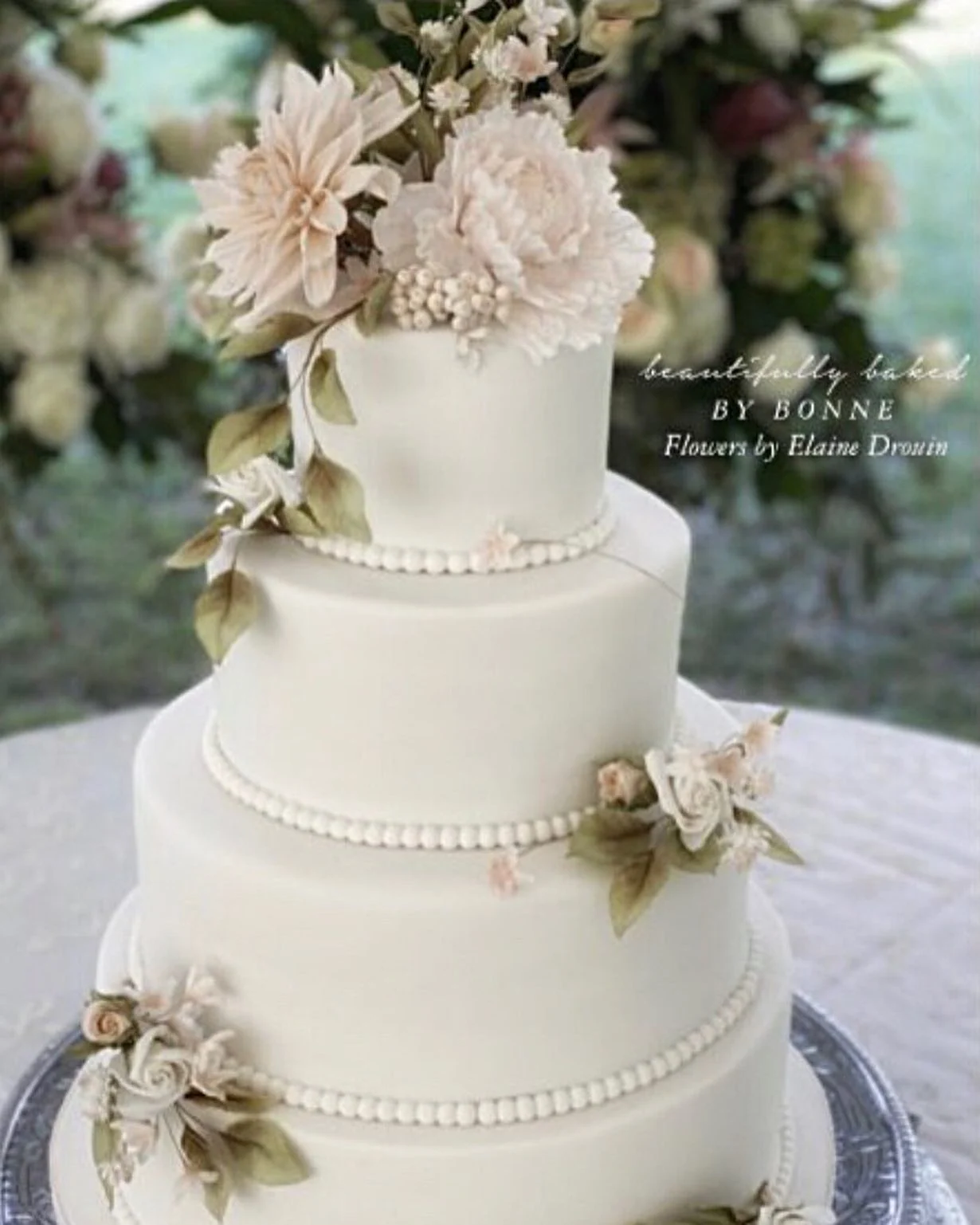 A classic buttercream wedding cake decorated with pale sugar flowers