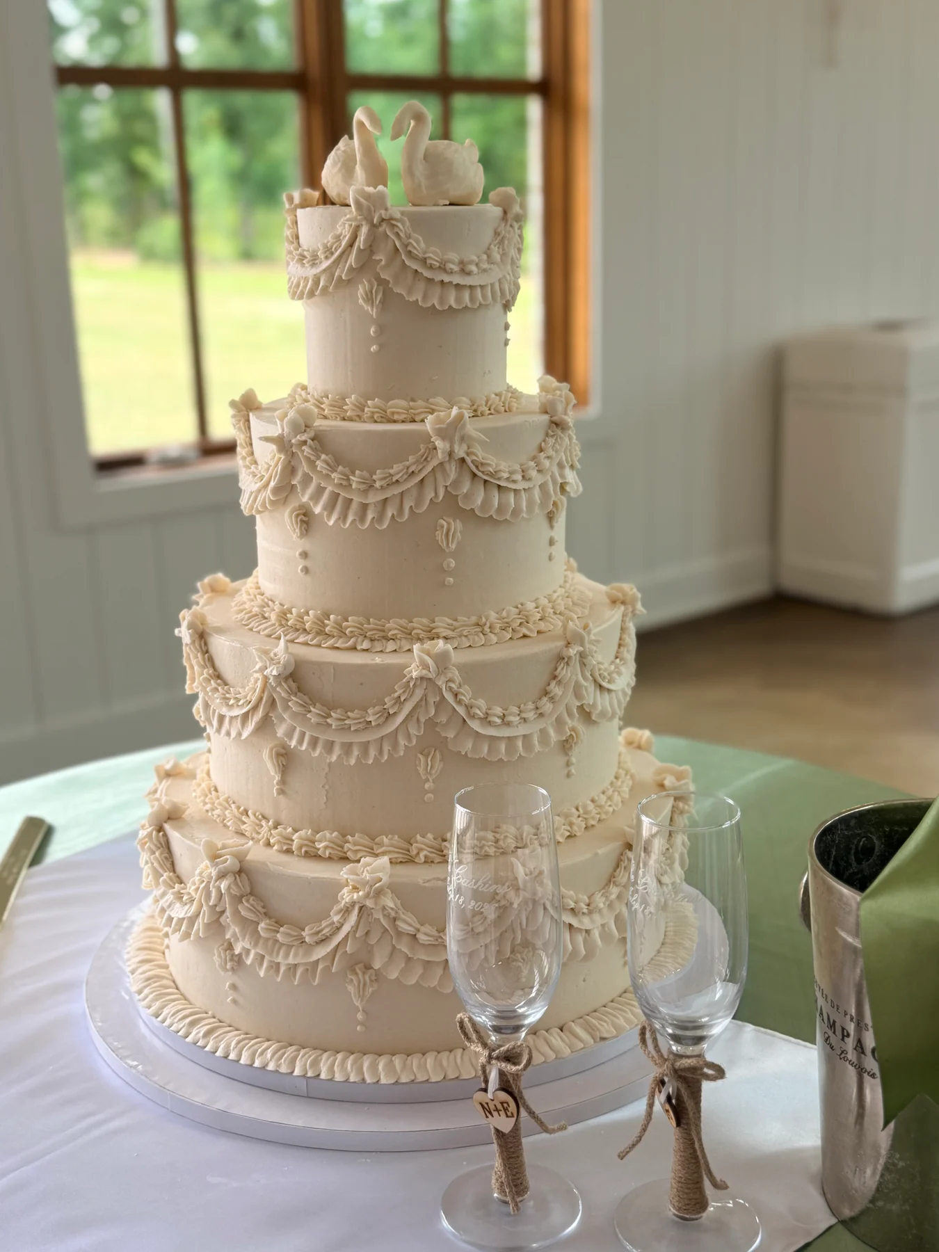 A tall tiered wedding cake displayed at the reception