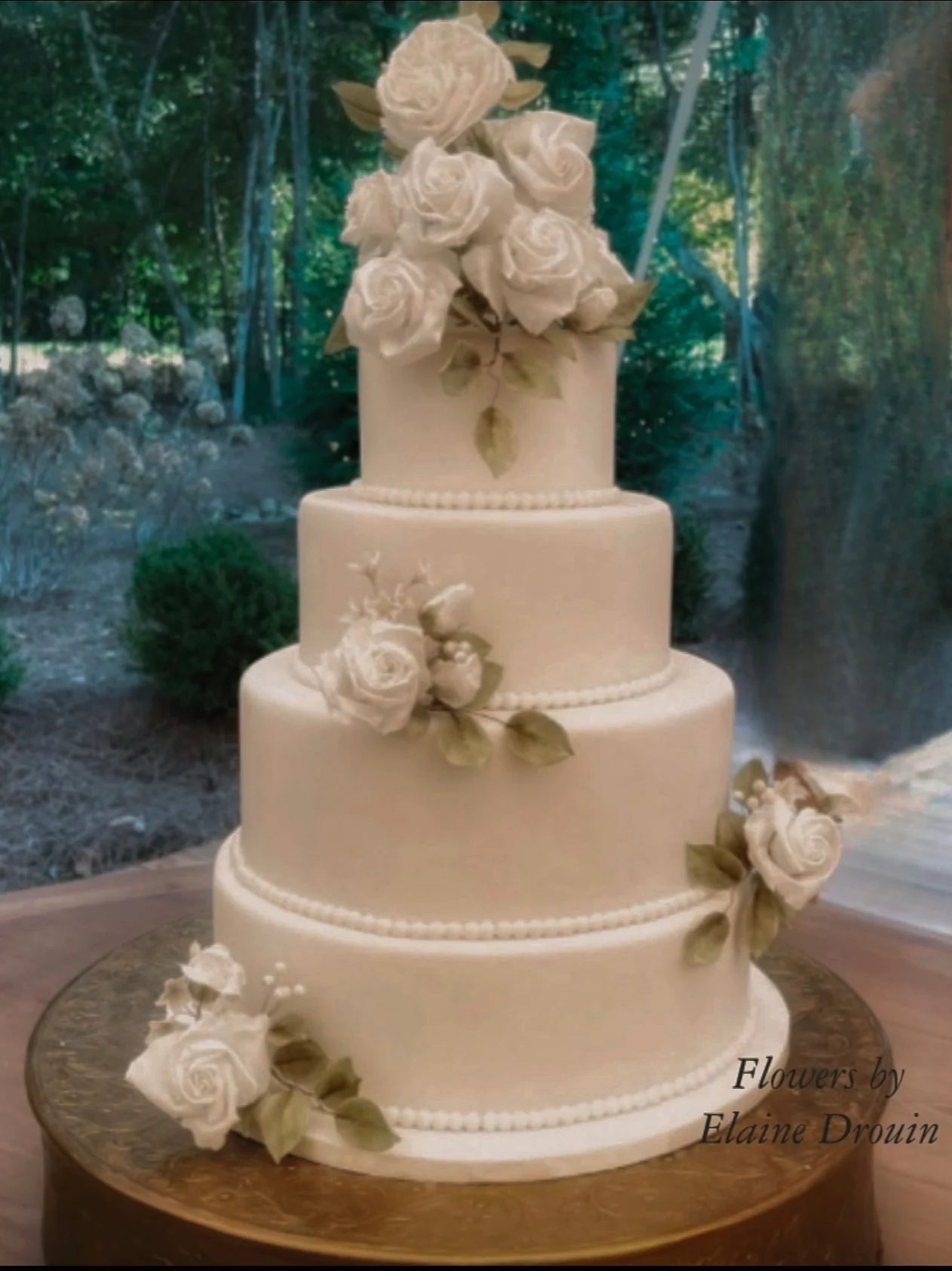 A tiered buttercream wedding cake with sculpted floral details