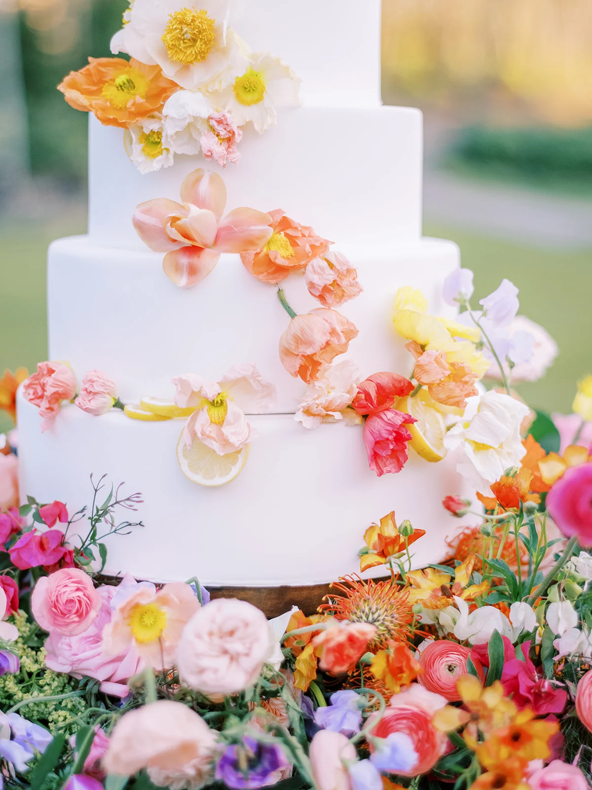 A white wedding cake with colorful sugar flowers